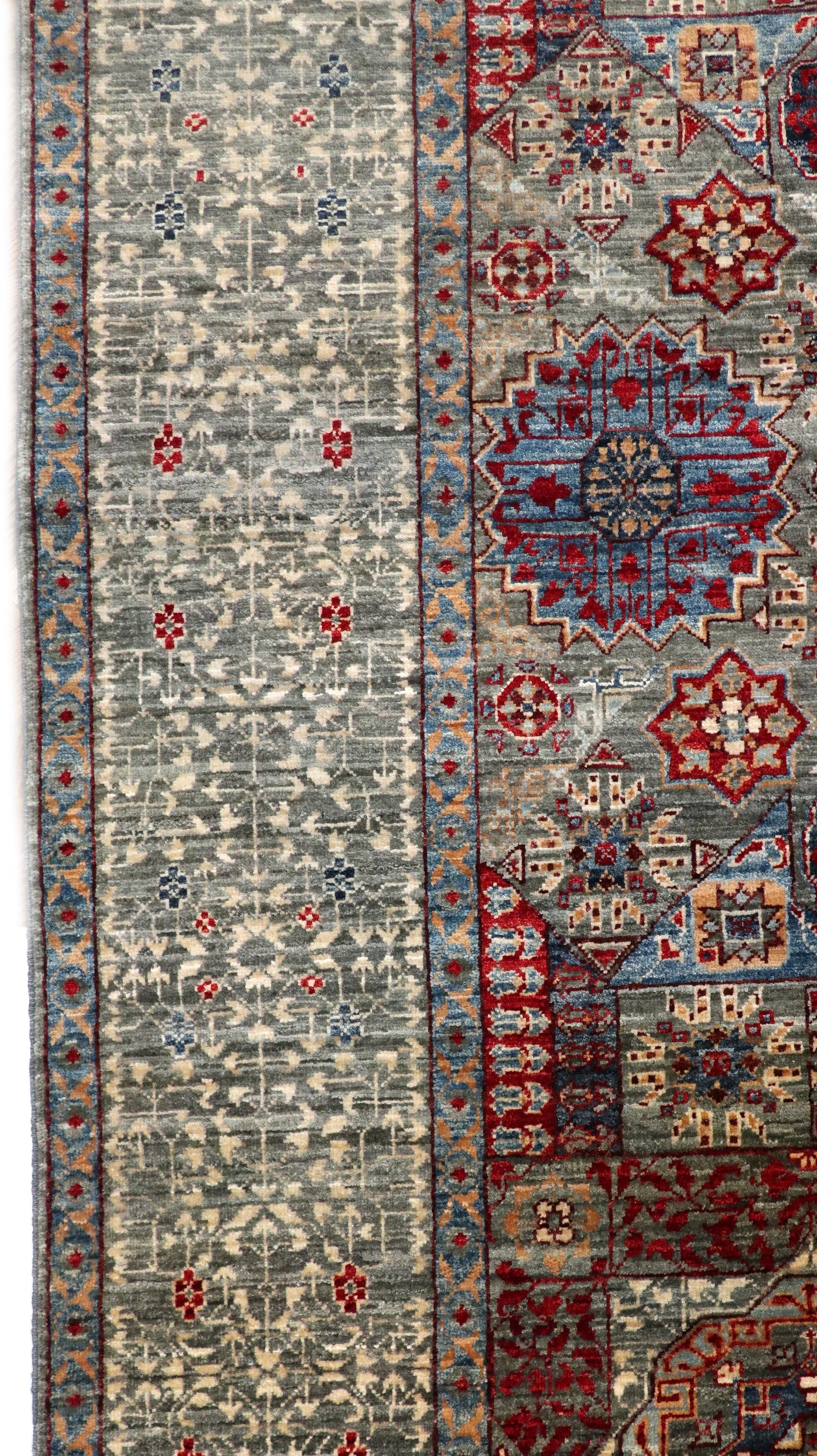 Hand-knotted intricate patterned rug in stormy sea gray and ocean blue with weathered red and stone accents.