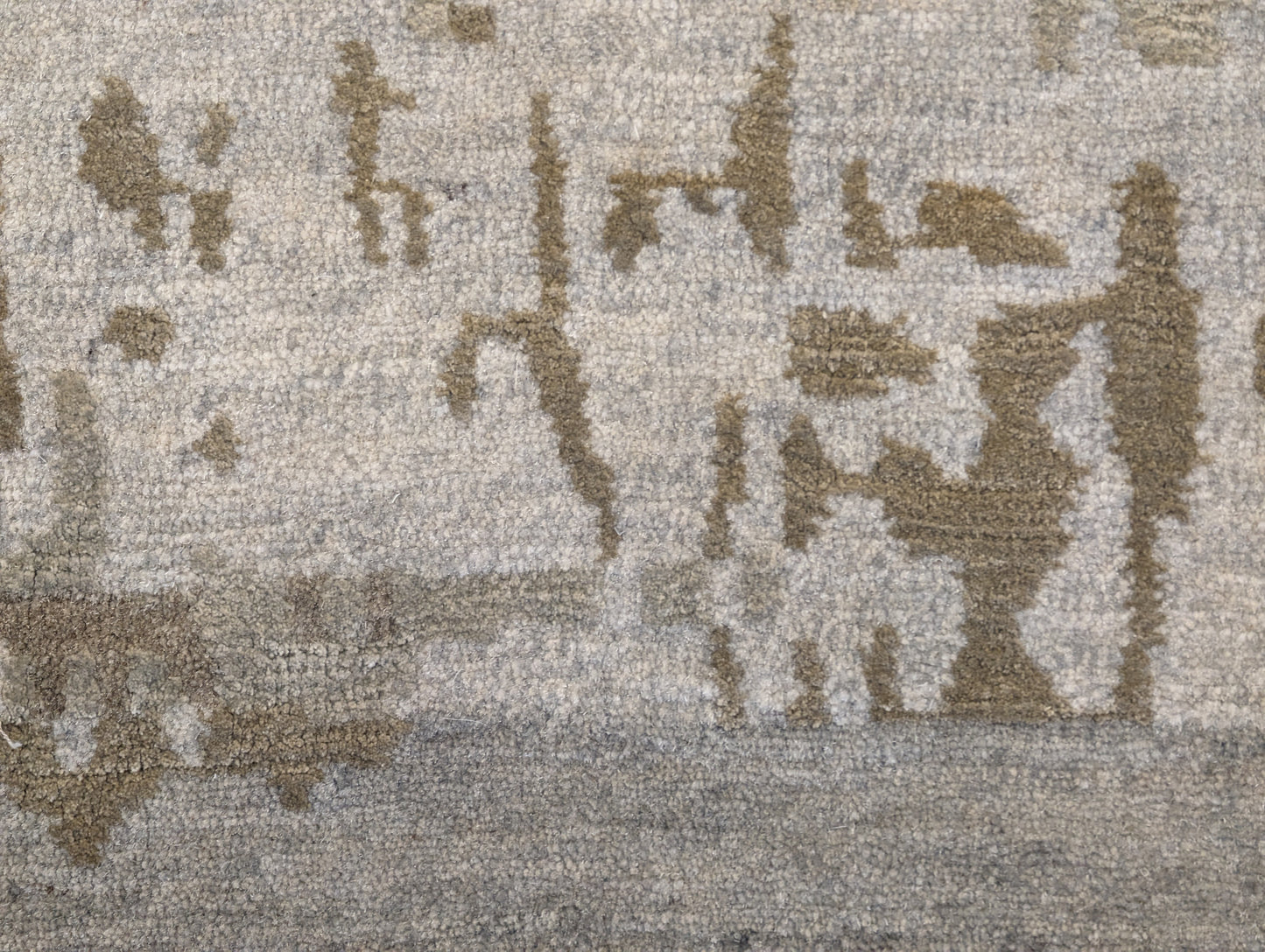A hand-knotted wool and silk rug with a coastal-inspired design in shades of taupe, smokey blue, and soft grey.