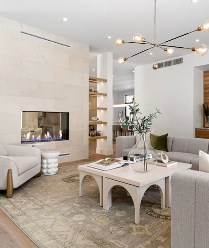 Modern living room with gray sofa, coffee table, and fireplace. The space is anchored by a cozy rug that perfectly unifies the décor.