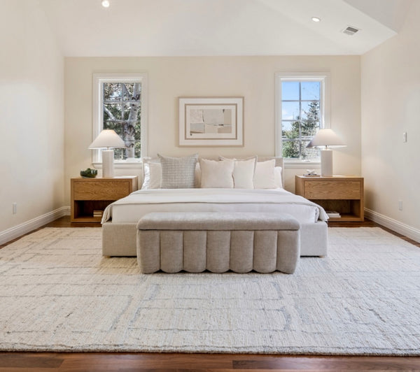 Modern bedroom with a bed, nightstands, and lamps. The space is anchored by a cozy rug that perfectly unifies the décor.