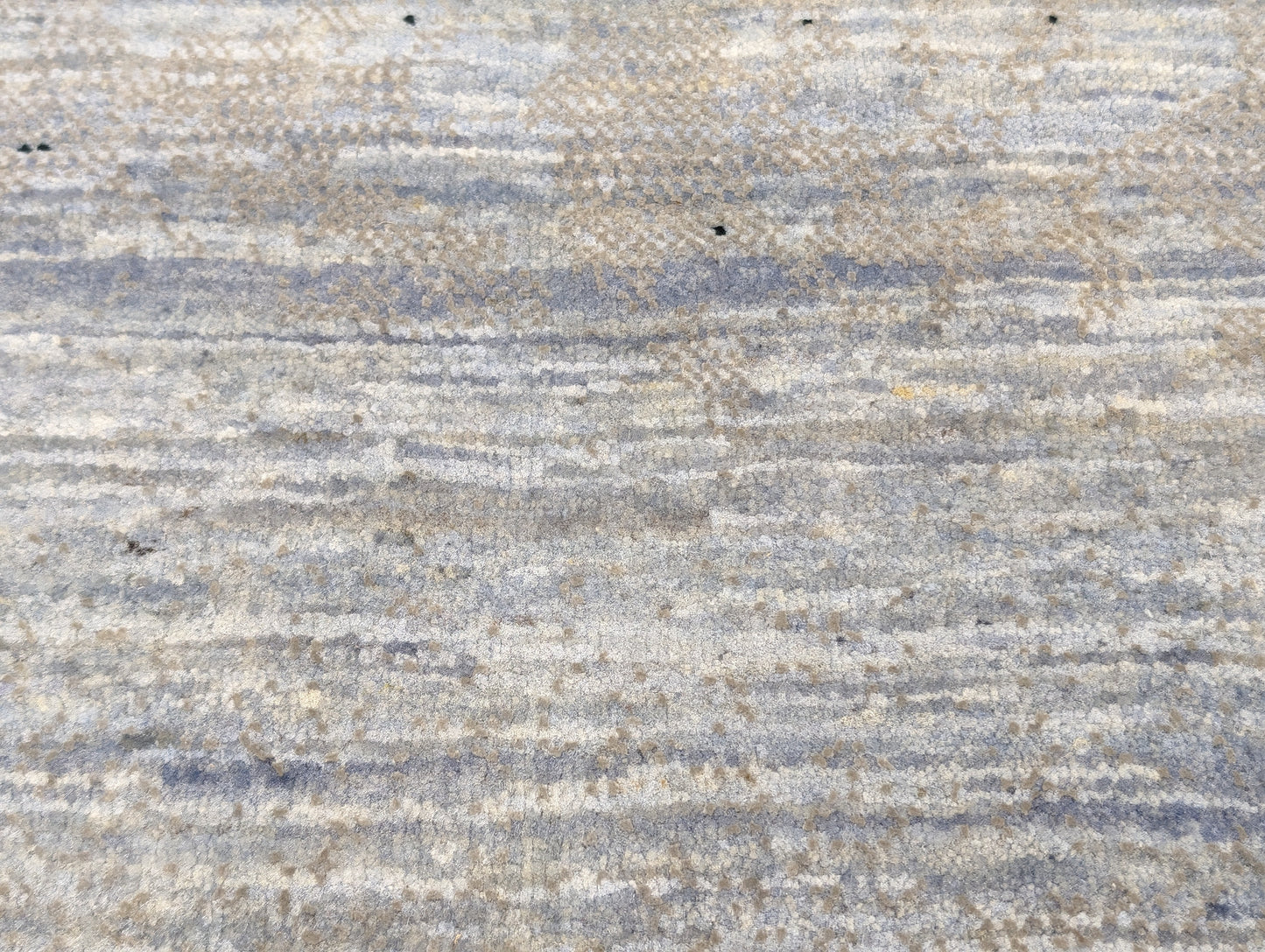A hand-knotted rug with a serene coastal aesthetic featuring shades of gray, blue, and green, and a unique hand-knotted design. Cozy wool and luxurious silk. 
