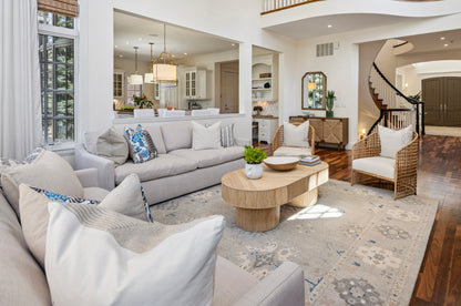 Living room with gray sectional sofa, coffee table, and decorative pillows. The space is anchored by a cozy rug that perfectly unifies the décor.