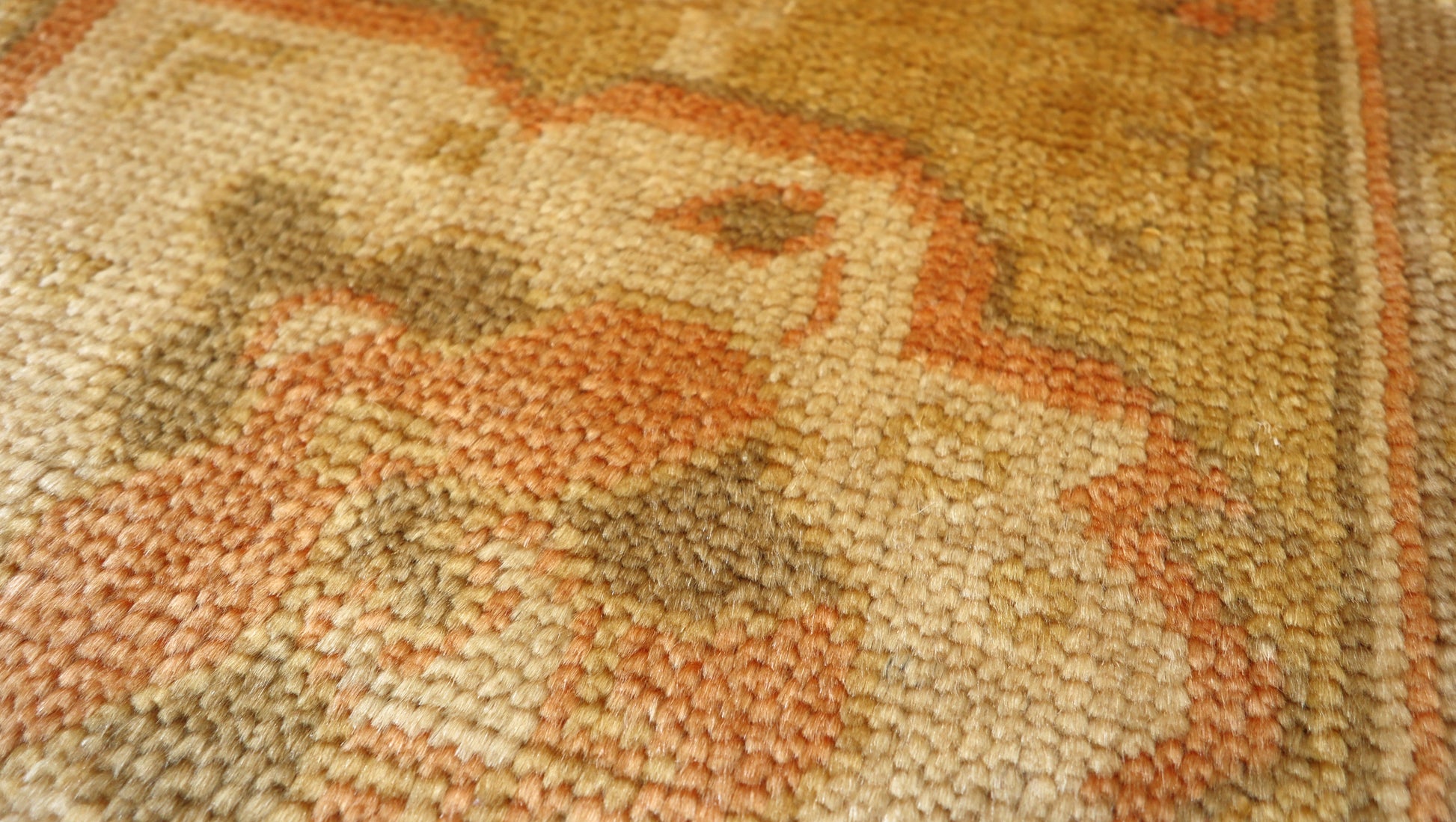 Hand-knotted mohair rug with a large knot and antique finish in oyster shell and sandy beige with dune grass green, rosehip pink, and gold accents.