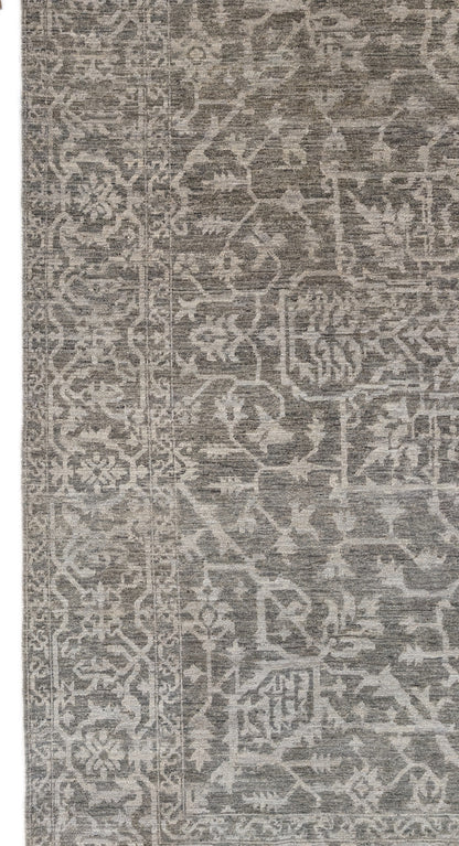 A hand-knotted wool rug with a subtle grey color palette, featuring intricate geometric patterns.