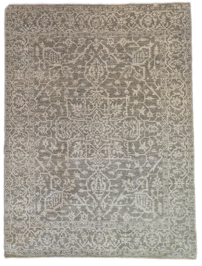 A hand-knotted wool rug with a subtle grey color palette, featuring intricate geometric patterns.