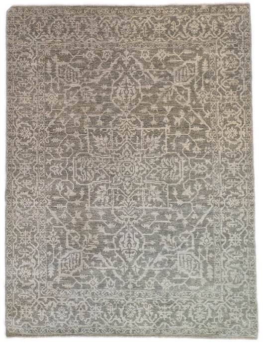 A hand-knotted wool rug with a subtle grey color palette, featuring intricate geometric patterns.