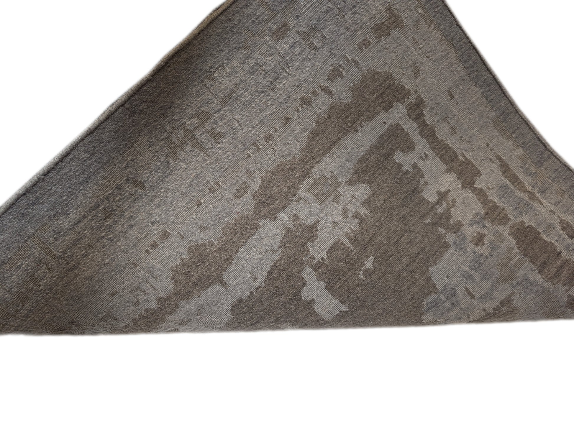 A hand-knotted wool and silk rug with a coastal-inspired design in shades of taupe, smokey blue, and soft grey.