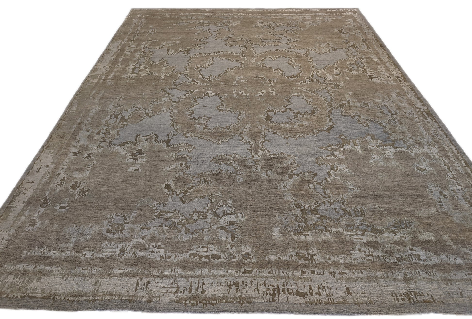 A hand-knotted wool and silk rug with a coastal-inspired design in shades of taupe, smokey blue, and soft grey.