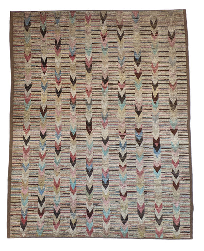 A hand-knotted wool rug with a coastal aesthetic in a plush design, featuring a mix of pink, red, yellow, blues, browns, and ivory colors.