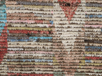 A hand-knotted wool rug with a coastal aesthetic in a plush design, featuring a mix of pink, red, yellow, blues, browns, and ivory colors.