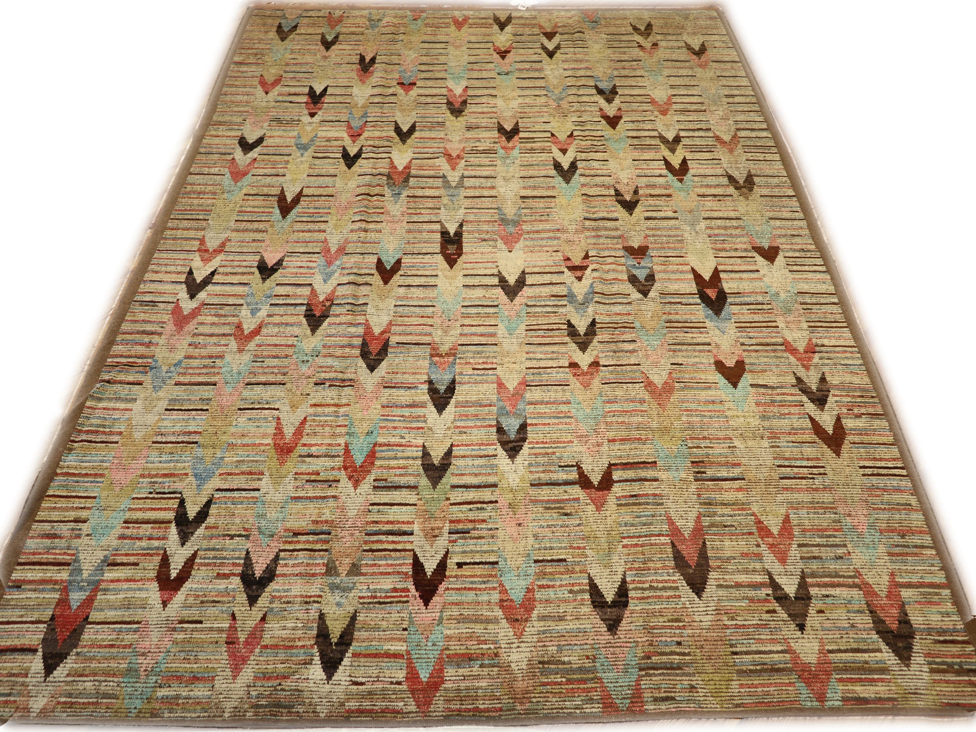 A hand-knotted wool rug with a coastal aesthetic in a plush design, featuring a mix of pink, red, yellow, blues, browns, and ivory colors.