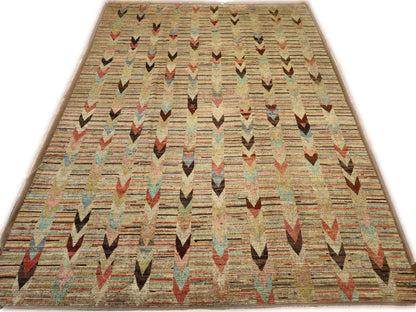 A hand-knotted wool rug with a coastal aesthetic in a plush design, featuring a mix of pink, red, yellow, blues, browns, and ivory colors.