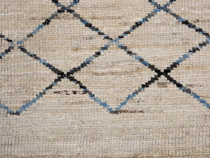 A hand-knotted wool rug with a geometric pattern in beige, brown, blue,  and gray tones, featuring a coastal aesthetic. Cozy pile. 