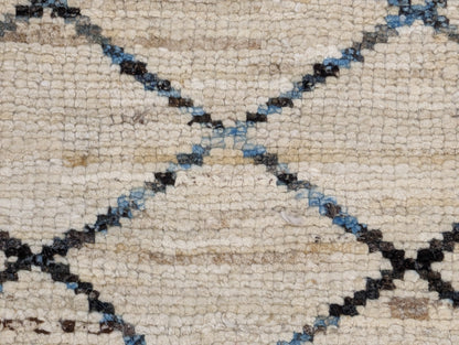 A hand-knotted wool rug with a geometric pattern in beige, brown, blue,  and gray tones, featuring a coastal aesthetic. Cozy pile. 