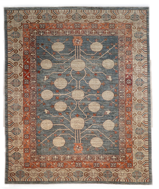 Hand-knotted decorative wool rug with a high pile in dusky ocean blue with sand, pebble gray, weathered red, and coral accents.