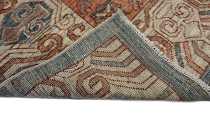 Hand-knotted decorative wool rug with a high pile in dusky ocean blue with sand, pebble gray, weathered red, and coral accents.