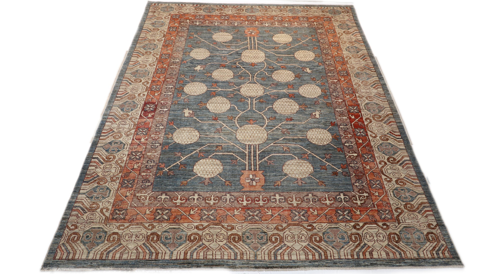 Hand-knotted decorative wool rug with a high pile in dusky ocean blue with sand, pebble gray, weathered red, and coral accents.