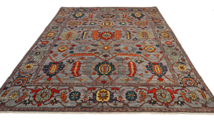 Transitional hand-knotted rug in muted gray-blue with faded coral red, soft orange, and sandy ochre accents.
