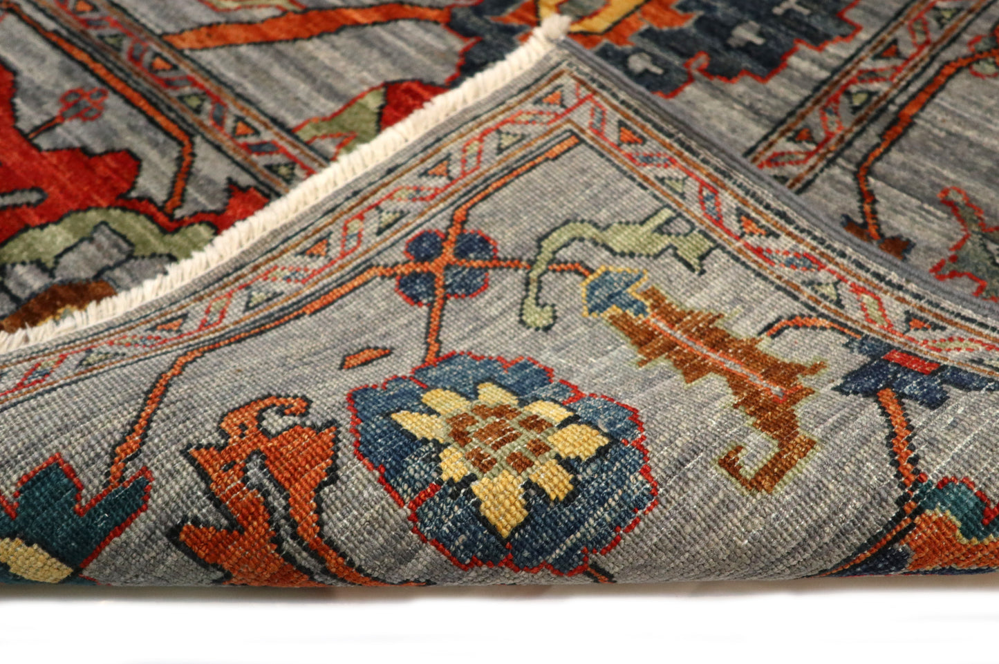 Transitional hand-knotted rug in muted gray-blue with faded coral red, soft orange, and sandy ochre accents.