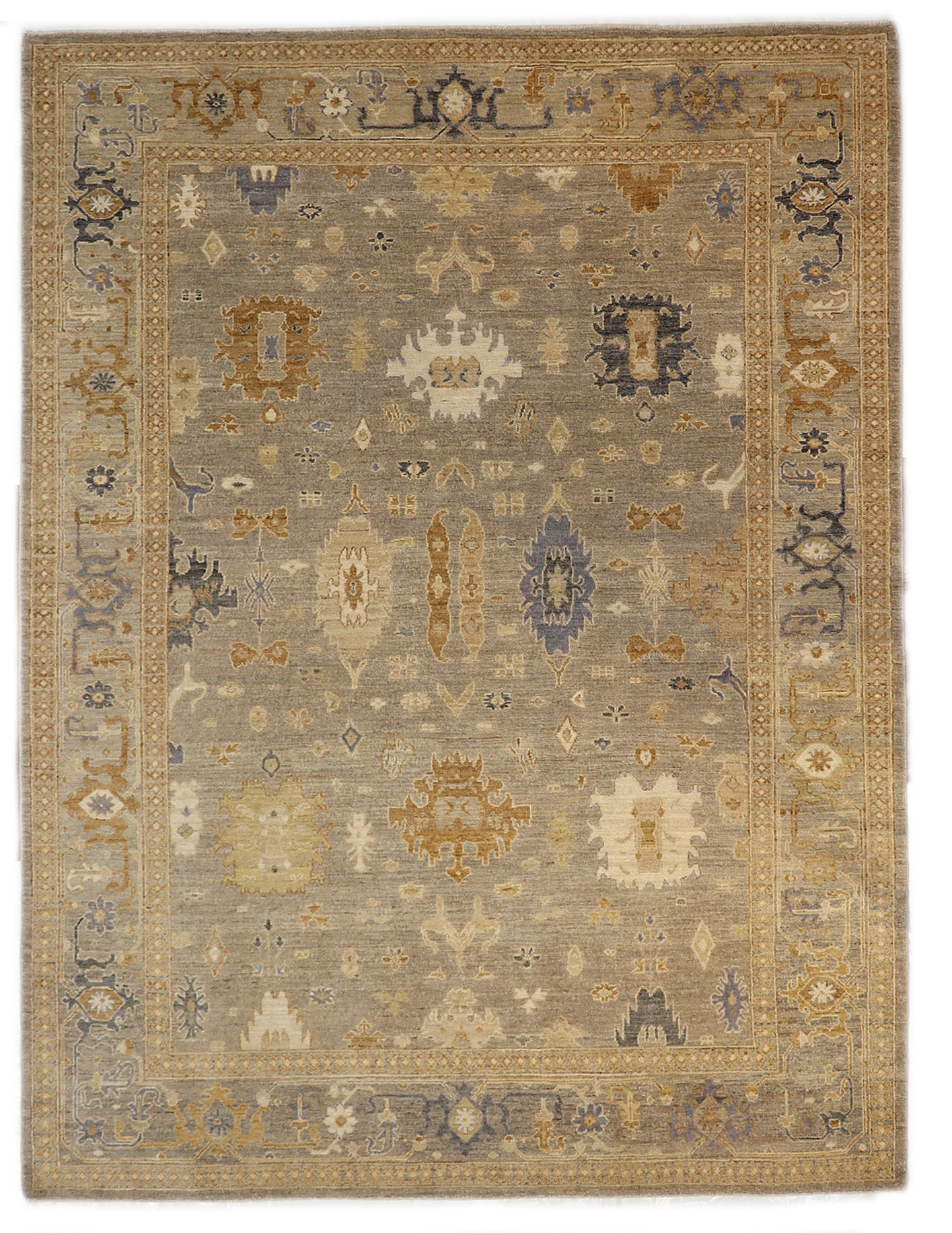 Hand-knotted wool rug in a traditional design featuring driftwood gray and sandy beige with sea glass blue and gold accents and a low pile.