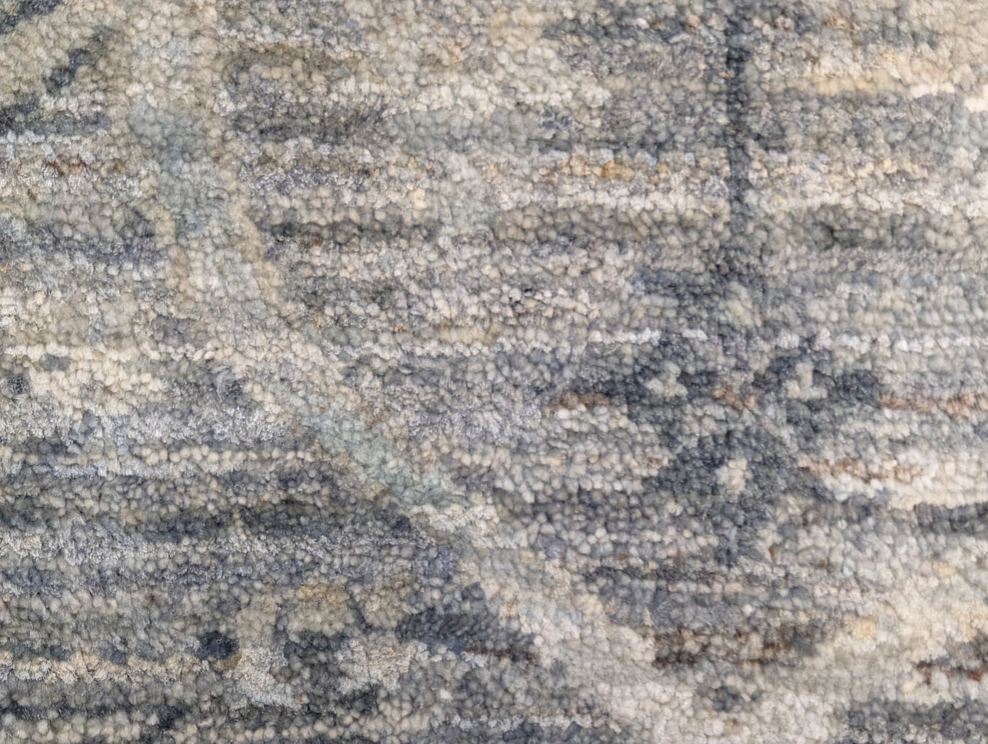A hand-knotted wool rug with a traditional and contemporary design, featuring coastal shades of grey, smokey blue, ivory, and brown.