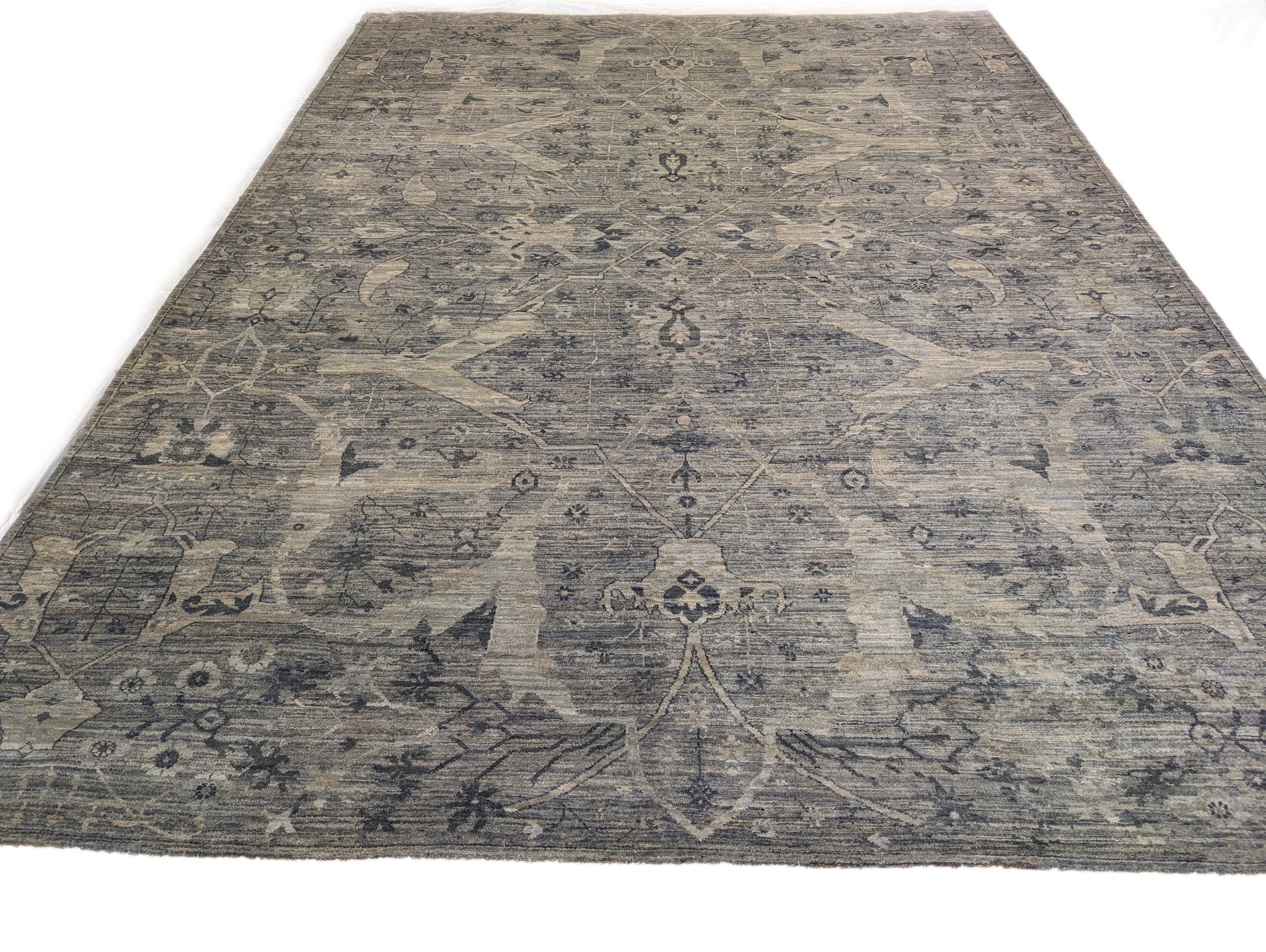 A hand-knotted wool rug with a traditional and contemporary design, featuring coastal shades of grey, smokey blue, ivory, and brown.
