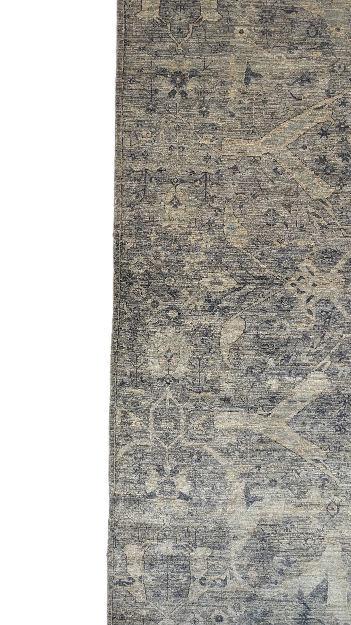 A hand-knotted wool rug with a traditional and contemporary design, featuring coastal shades of grey, smokey blue, ivory, and brown.