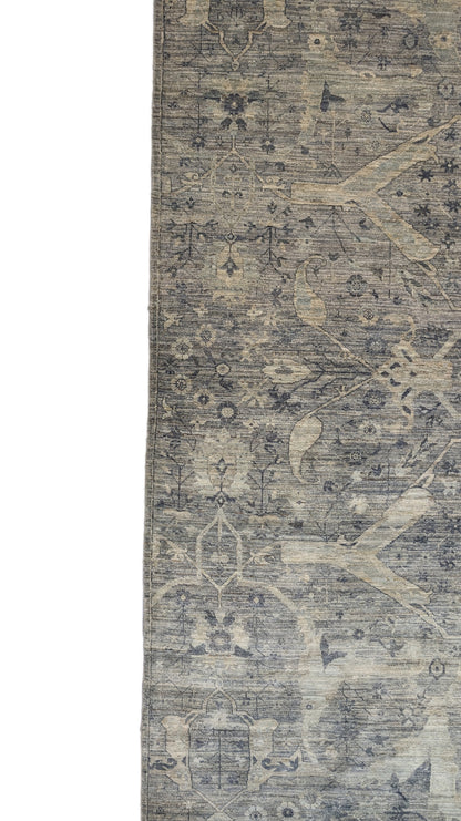A hand-knotted wool rug with a traditional and contemporary design, featuring coastal shades of grey, smokey blue, ivory, and brown.