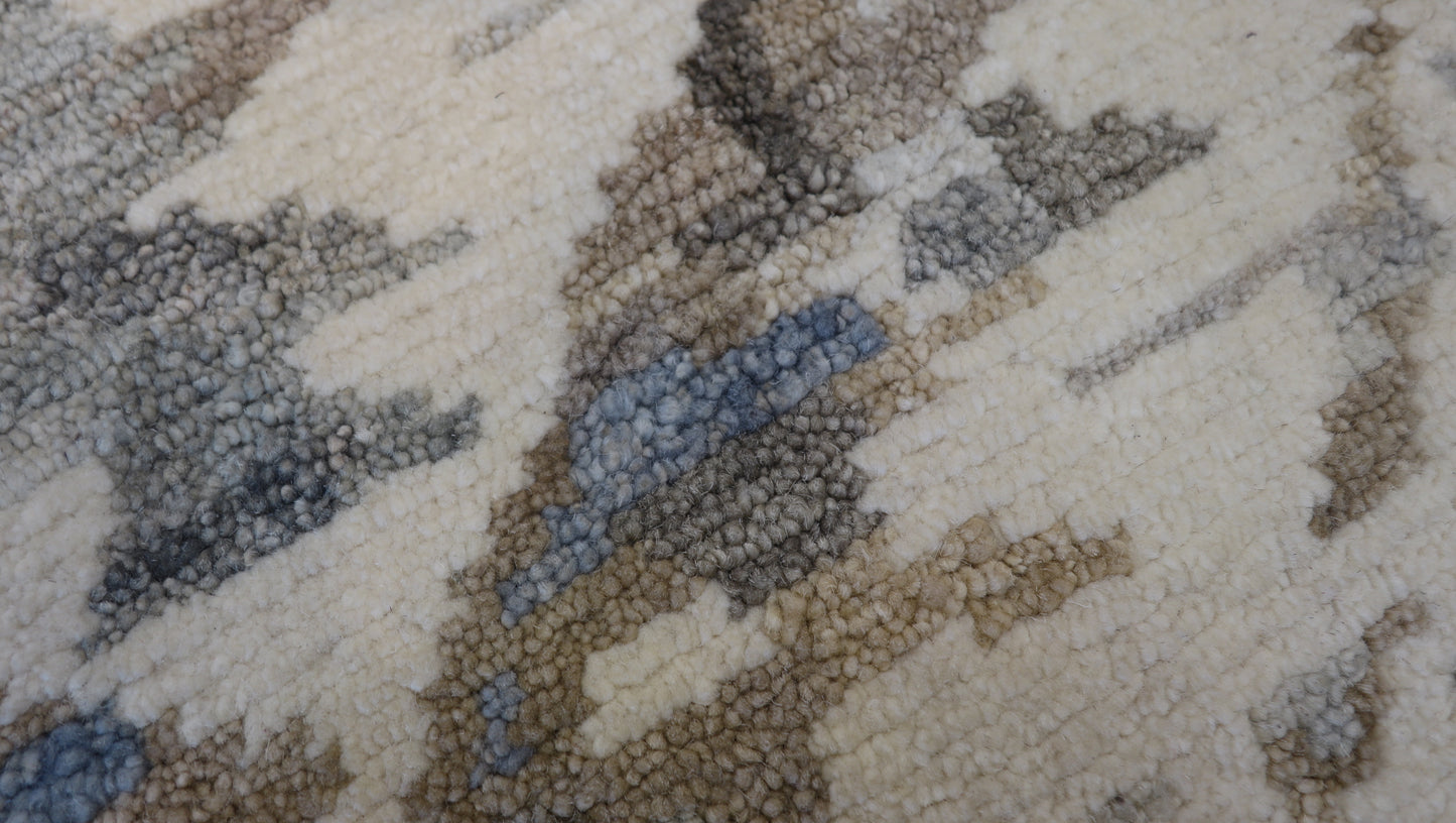 Hand- knotted patterned rug with geometric design in beige, brown, and gray tones. Cozy pile 