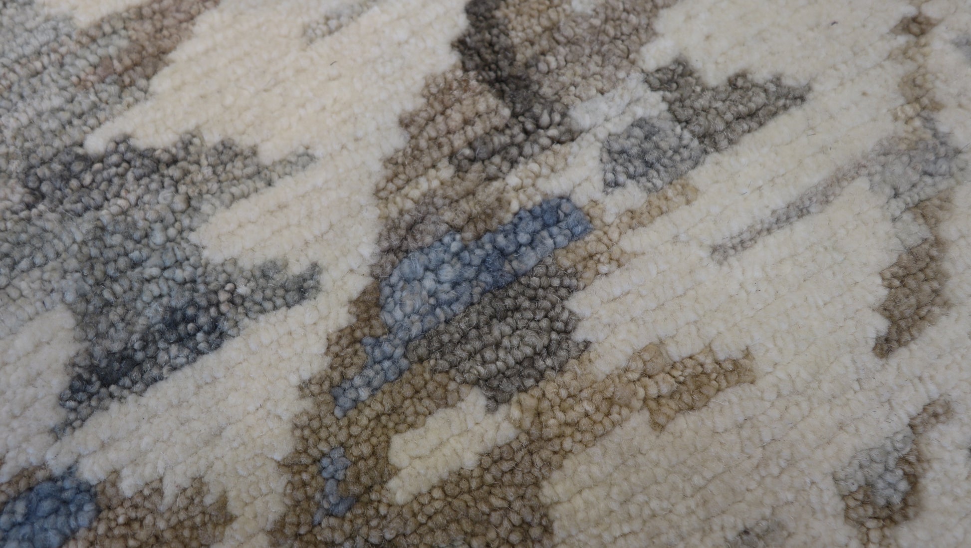 Hand- knotted patterned rug with geometric design in beige, brown, and gray tones. Cozy pile 