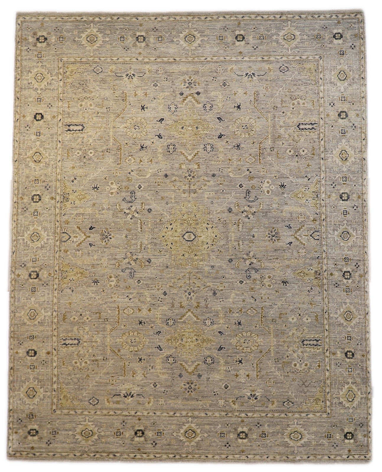 Hand-knotted wool rug with an antique finish in mist-gray, sand, and pale seagrass green with gold accents.
