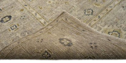 Hand-knotted wool rug with an antique finish in mist-gray, sand, and pale seagrass green with gold accents.
