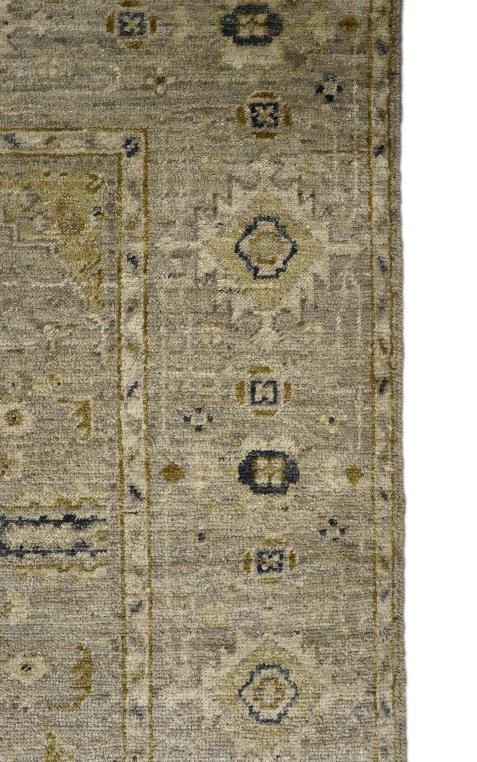 Hand-knotted wool rug with an antique finish in mist-gray, sand, and pale seagrass green with gold accents.