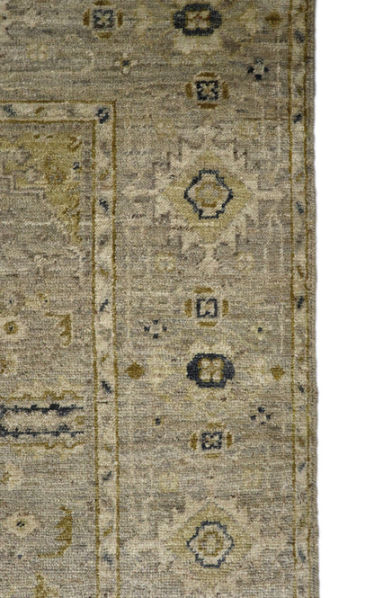 Hand-knotted wool rug with an antique finish in mist-gray, sand, and pale seagrass green with gold accents.