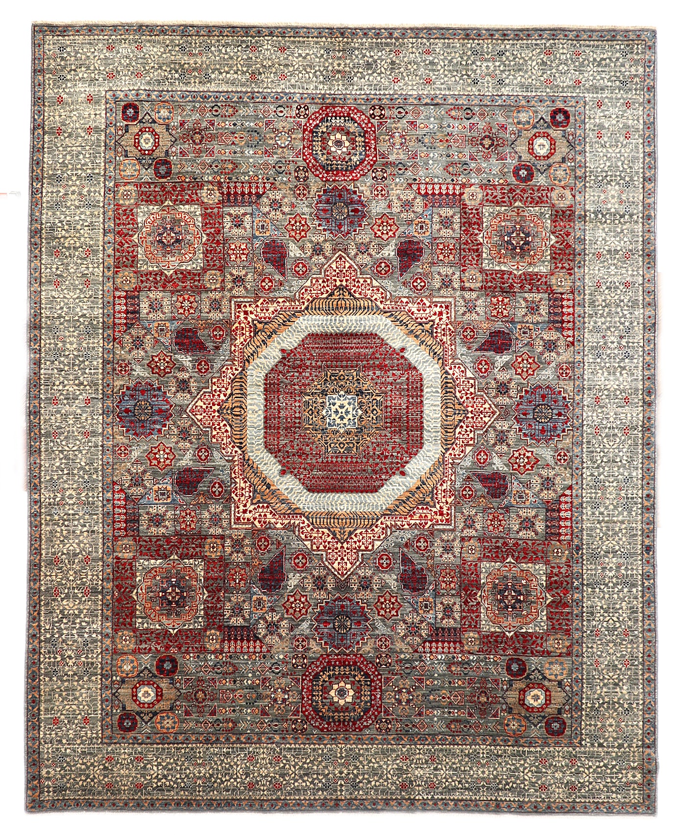 Hand-knotted intricate patterned rug in stormy sea gray and ocean blue with weathered red and stone accents.