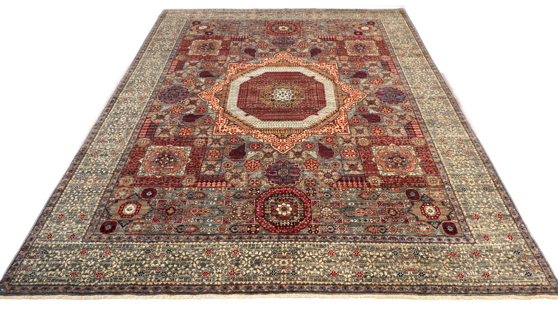 Hand-knotted intricate patterned rug in stormy sea gray and ocean blue with weathered red and stone accents.