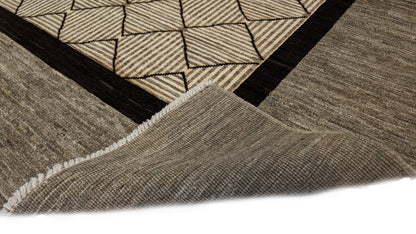 A hand-knotted wool rug with a geometric pattern in natural tones of beige, brown, and gray. Cozy pile. 