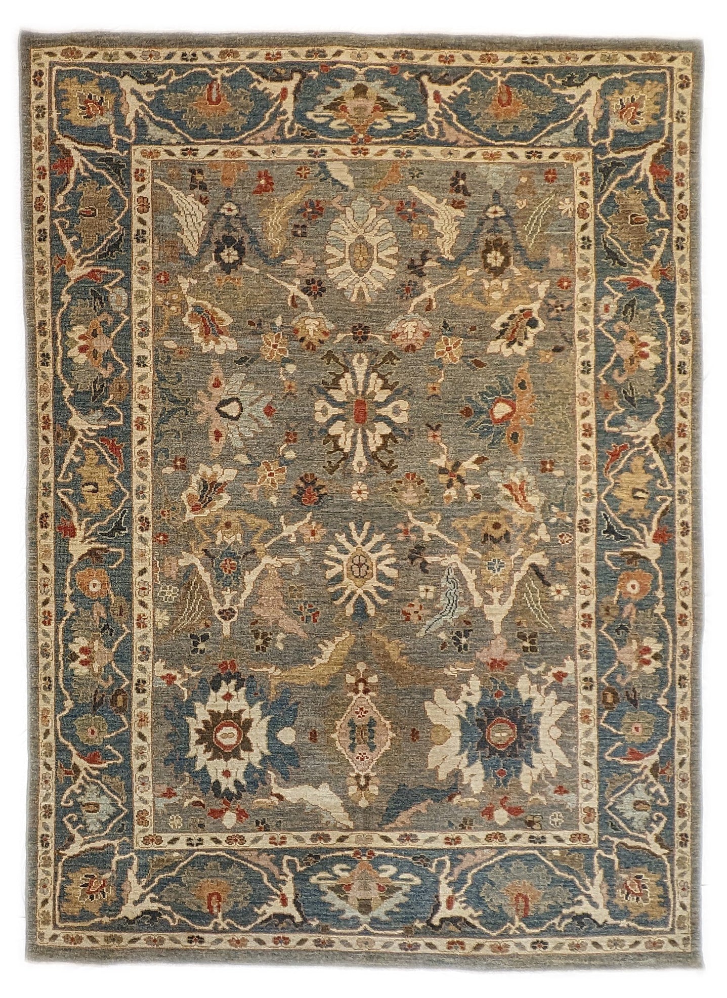 A hand-knotted wool rug with a traditional and contemporary design, featuring a rich palette of colors including slate grey, red, gold, pink, blue, green, and beige, and decorative border patterns.