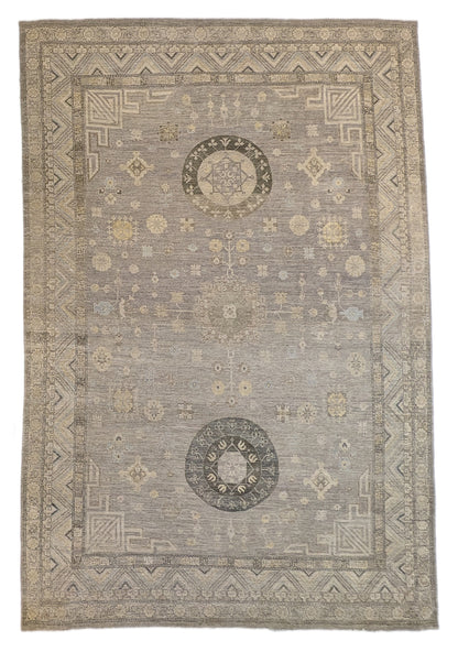 A hand-knotted wool rug with a coastal palette of sandy taupe, yellow, subtle grey, soft blue, and ivory, featuring traditional and contemporary geometric patterns.