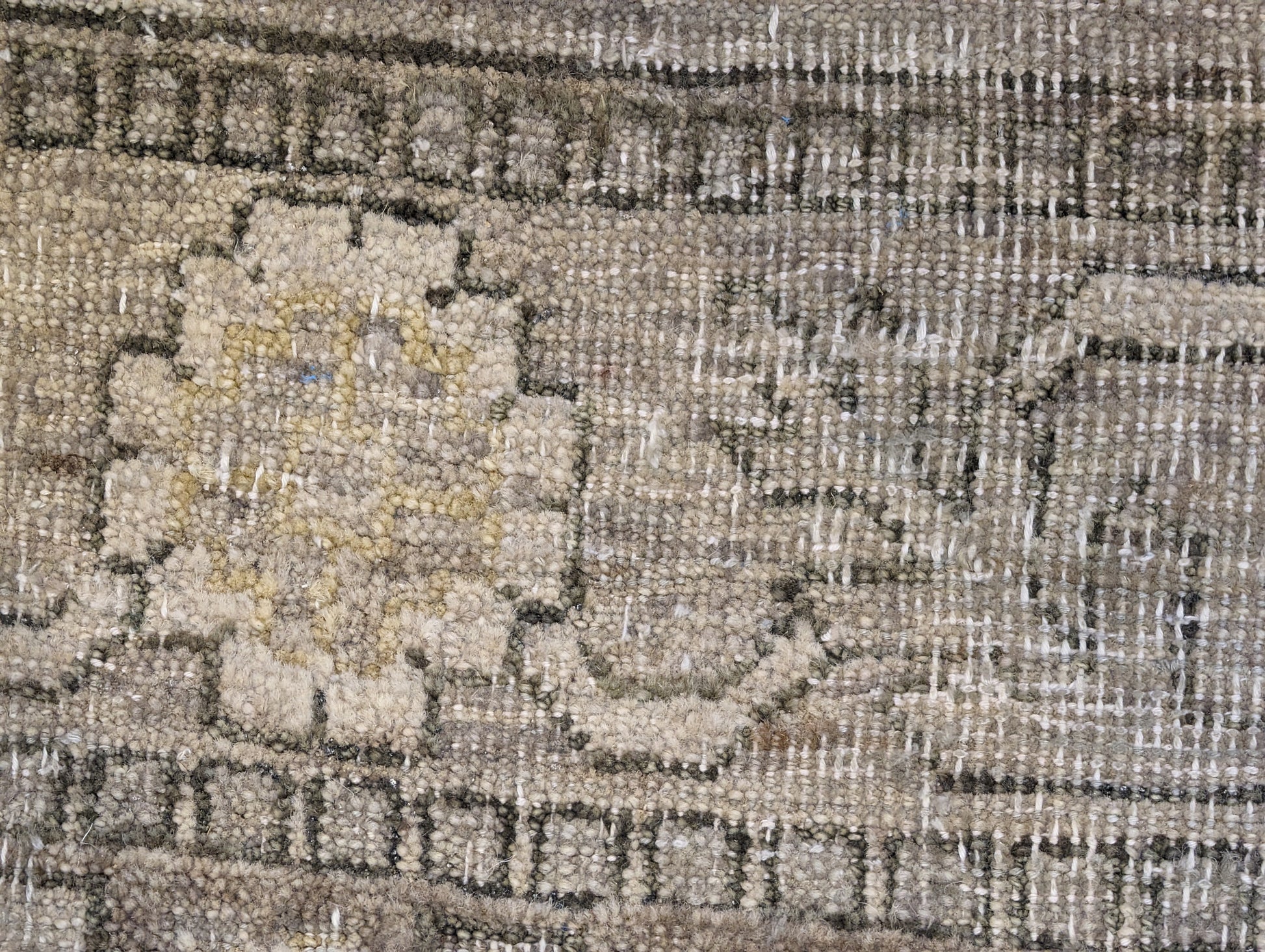 A hand-knotted wool rug with a coastal palette of sandy taupe, yellow, subtle grey, soft blue, and ivory, featuring traditional and contemporary geometric patterns.