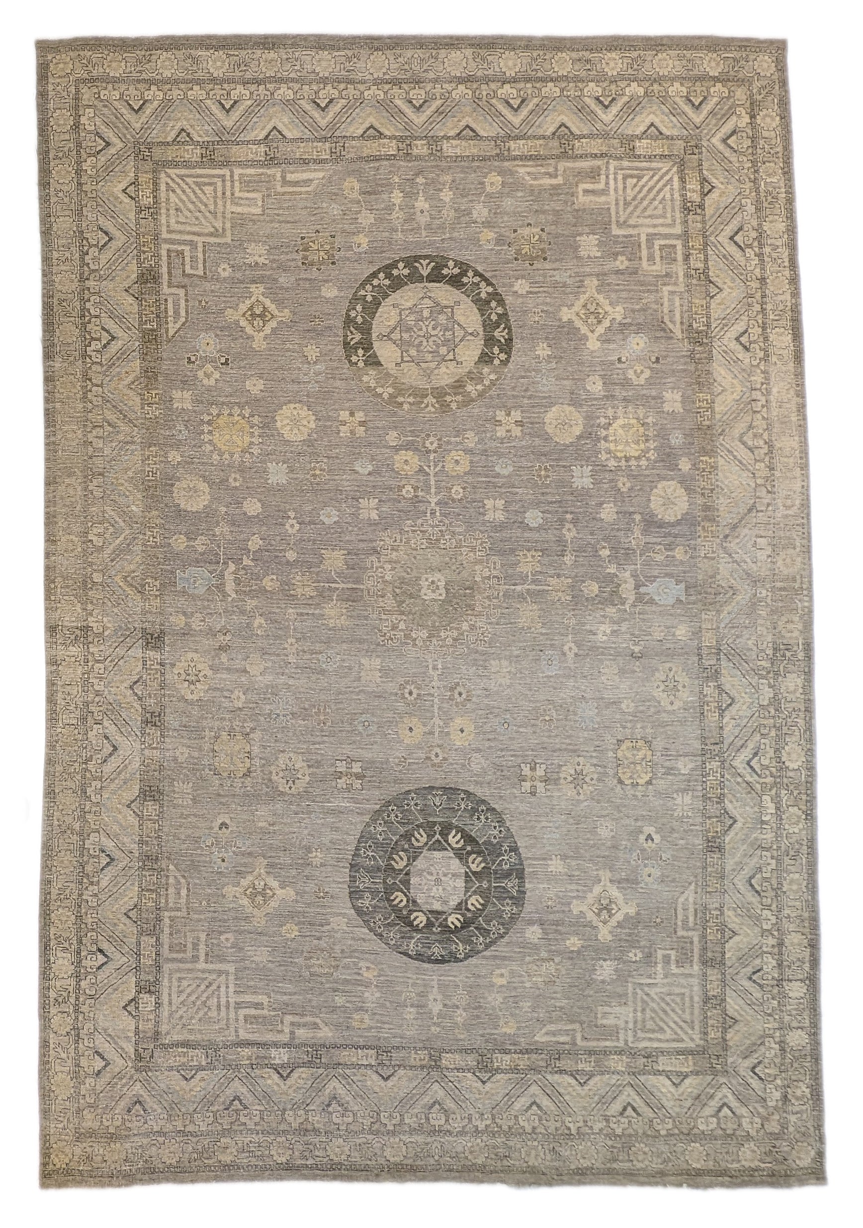 A hand-knotted wool rug with a coastal palette of sandy taupe, yellow, subtle grey, soft blue, and ivory, featuring traditional and contemporary geometric patterns.
