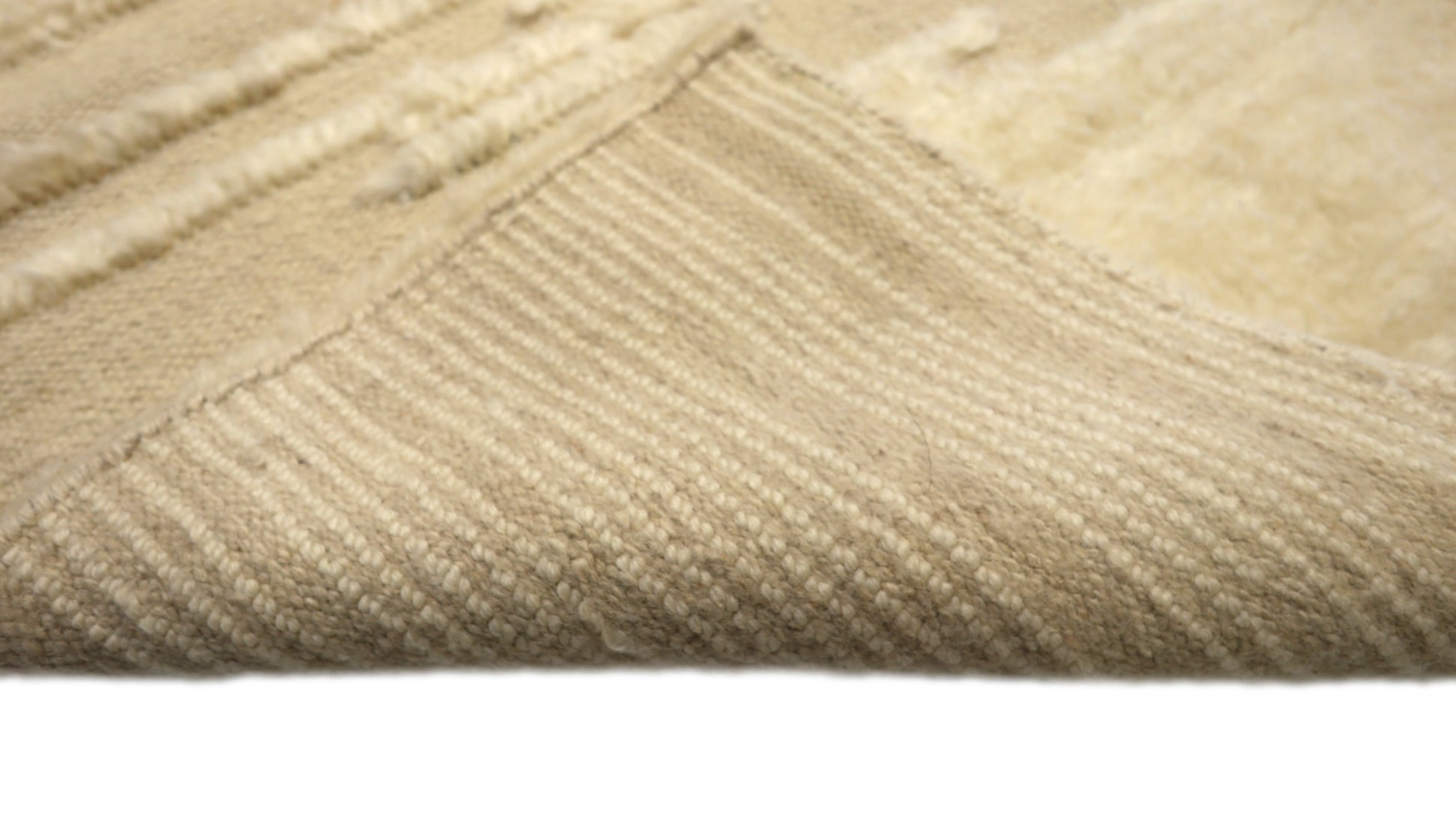Hand-knotted high-low pile wool rug in natural undyed ivory and warm sandy beige with a large knot texture.