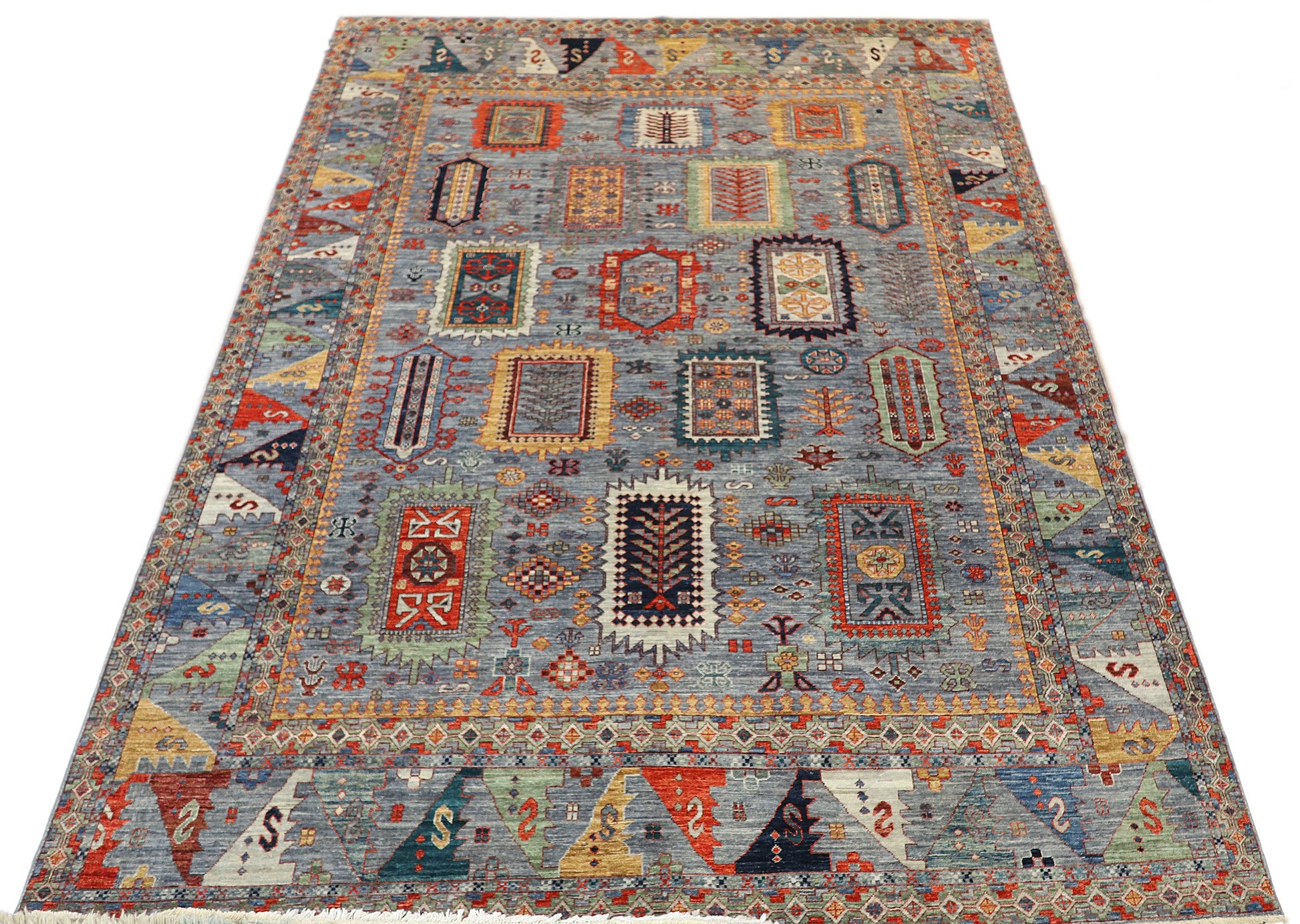 Hand-knotted decorative rug with geometric pattern with bluish-gray base sea glass blues and greens warm red and golden beige tones.