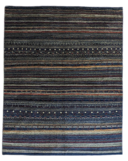 A hand-knotted wool rug with a geometric pattern in a variety of coastal hues including deep navy blue, red, warm orange, green, cheerful yellow, and soft ivory. Cozy pile. 