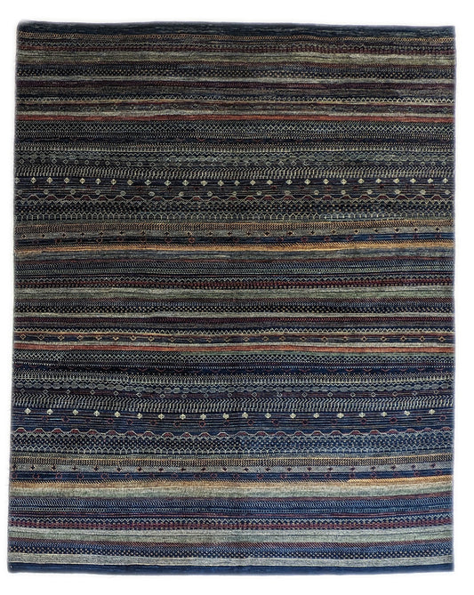 A hand-knotted wool rug with a geometric pattern in a variety of coastal hues including deep navy blue, red, warm orange, green, cheerful yellow, and soft ivory. Cozy pile. 
