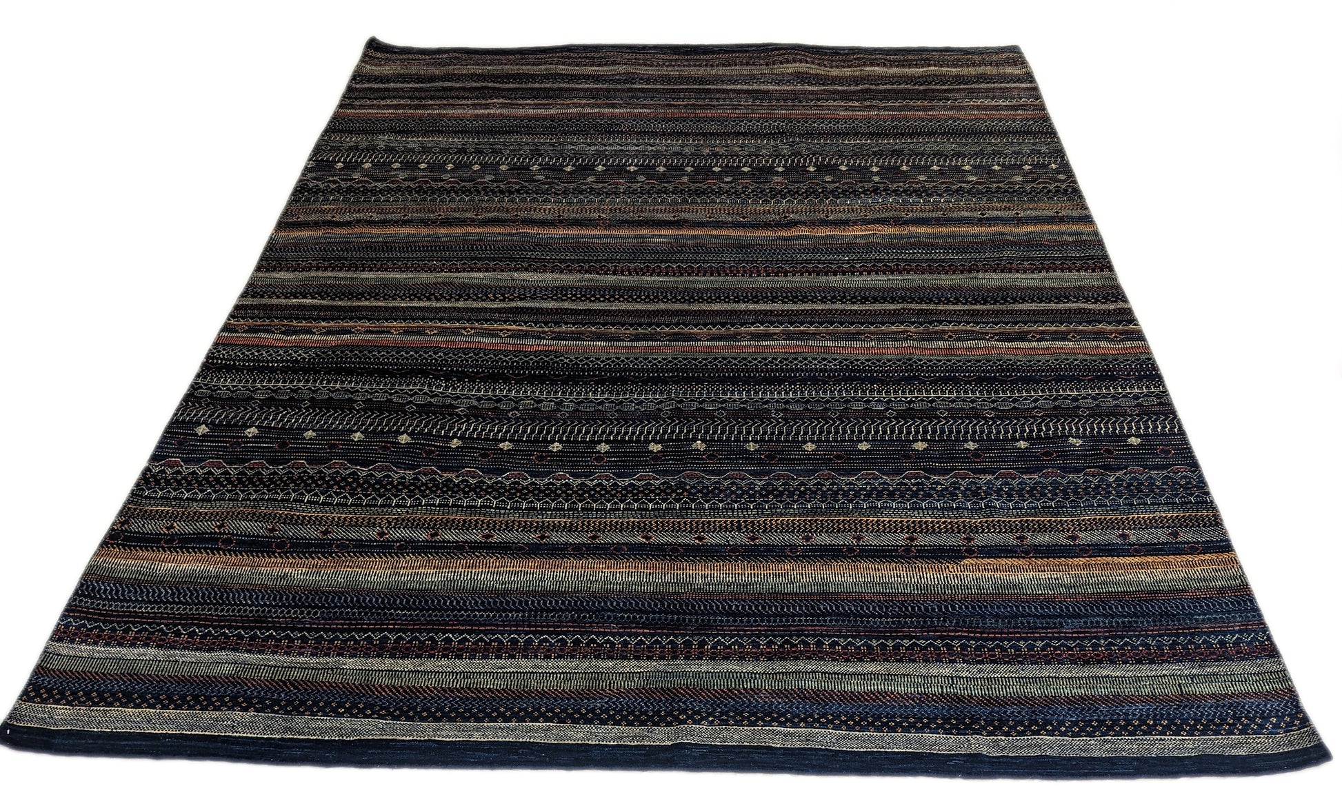 A hand-knotted wool rug with a geometric pattern in a variety of coastal hues including deep navy blue, red, warm orange, green, cheerful yellow, and soft ivory. Cozy pile. 
