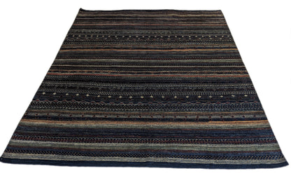 A hand-knotted wool rug with a geometric pattern in a variety of coastal hues including deep navy blue, red, warm orange, green, cheerful yellow, and soft ivory. Cozy pile. 