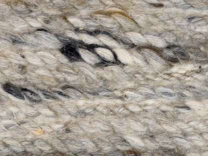 A hand-knotted wool rug with a coastal-inspired design in shades of light blue, beige, ivory, and brown. Cozy pile. 