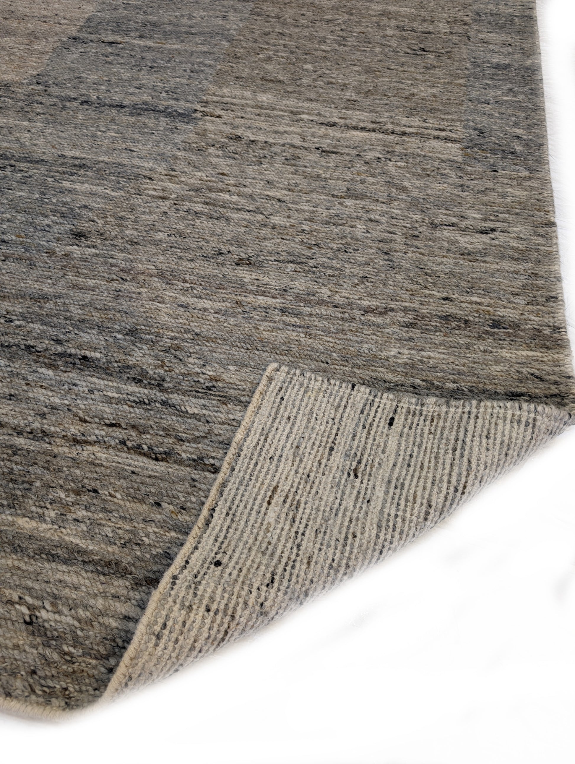 A hand-knotted wool rug with a coastal-inspired design in shades of light blue, beige, ivory, and brown. Cozy pile. 