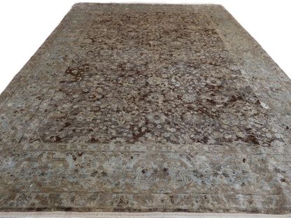 A hand-knotted silk and wool rug featuring a traditional and contemporary coastal design with natural tones of brown, taupe, light blue, grey, and ivory.